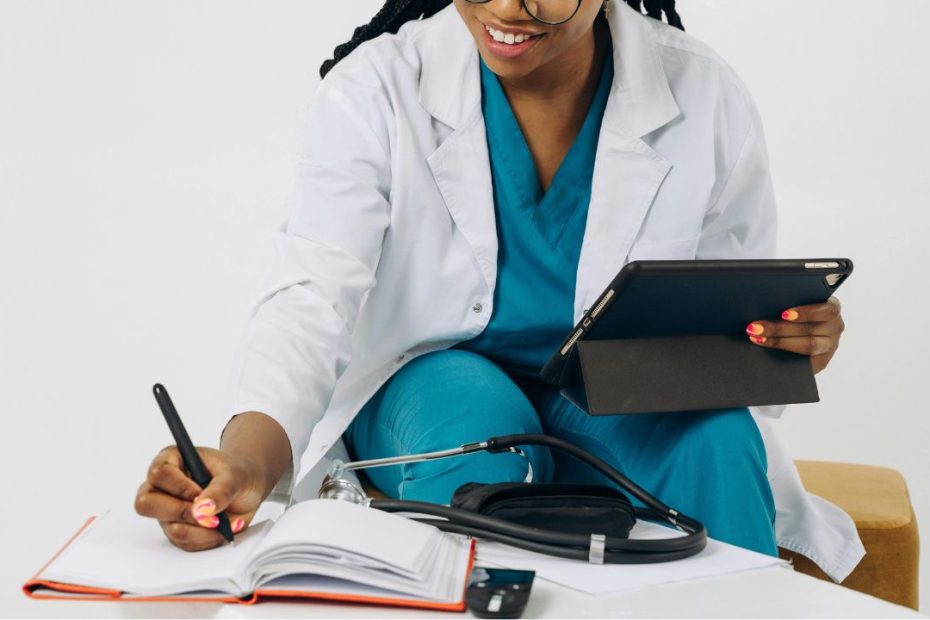 Female doctor using ipad and taking notes